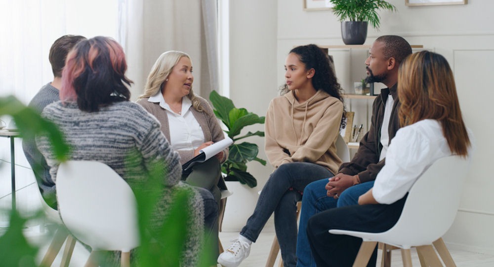 therapist addressing small group in therapy