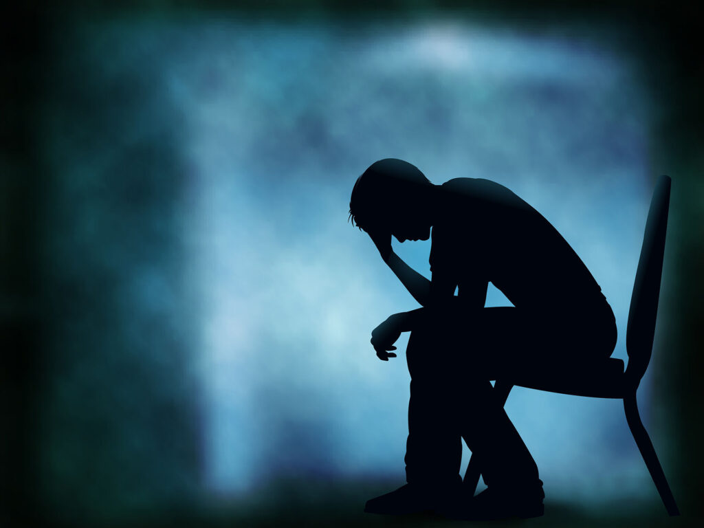 silhouette of a person sitting on a chair with blue and black background