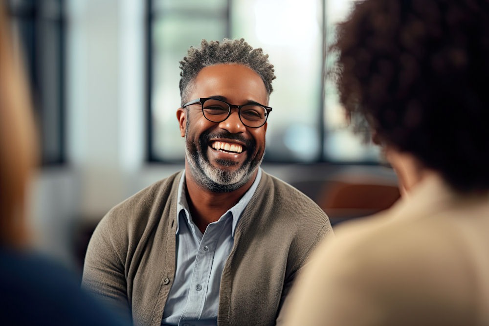 man smiling in group setting