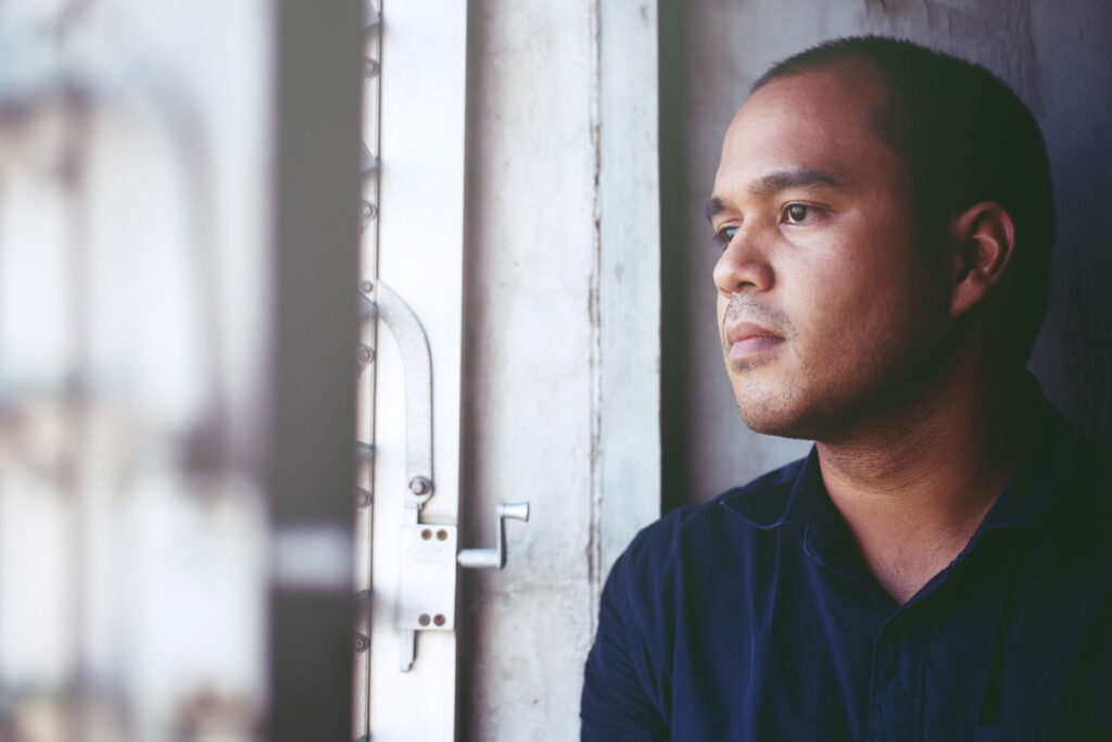 man standing in doorway looking outside