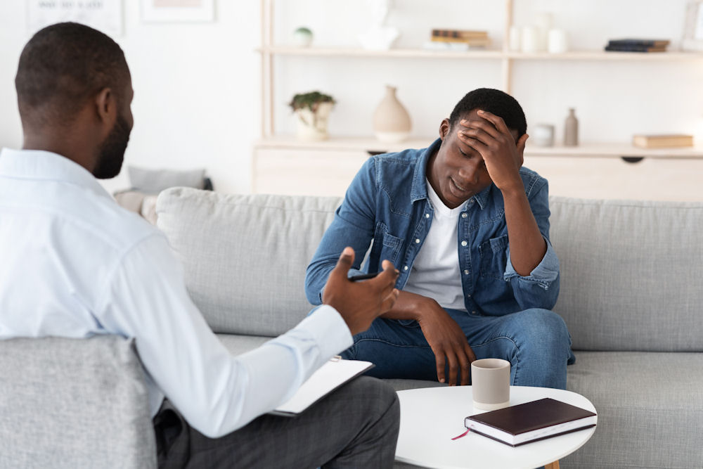 man sitting on couch across from therapist