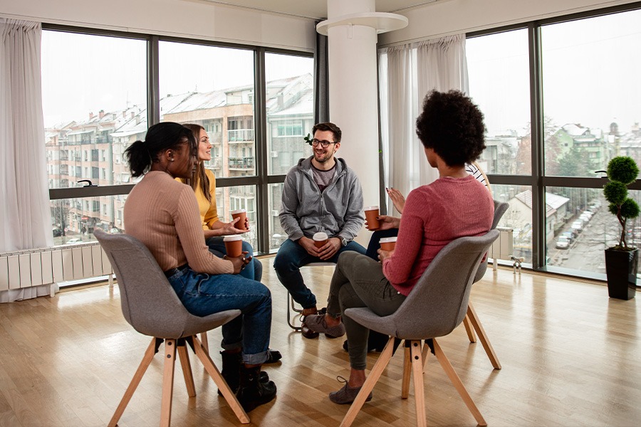 group of people sitting in chairs in a circle for group therapy