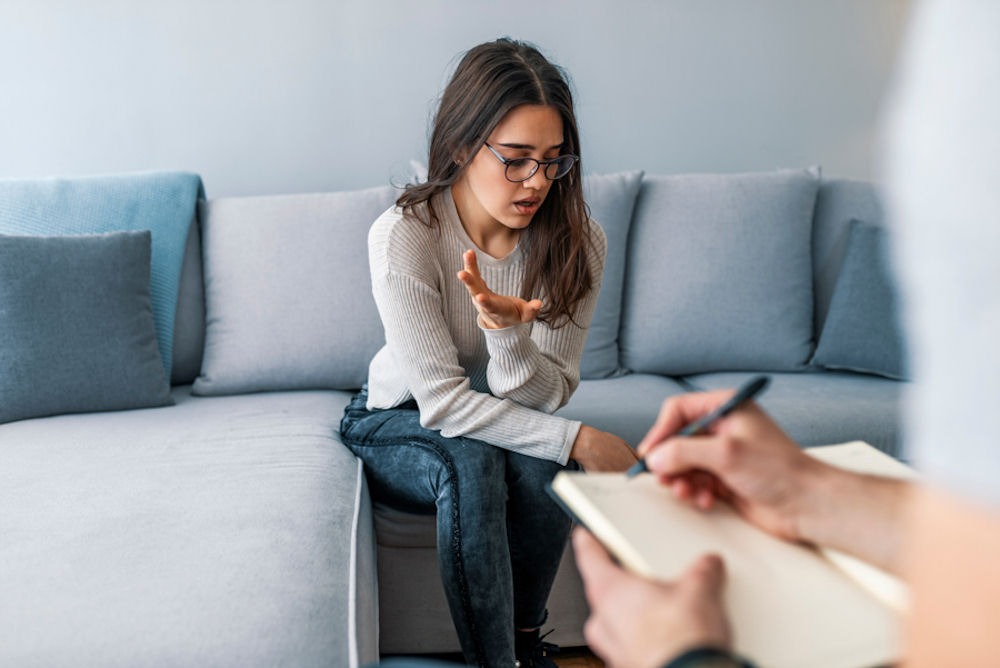 woman with hand up in therapy session