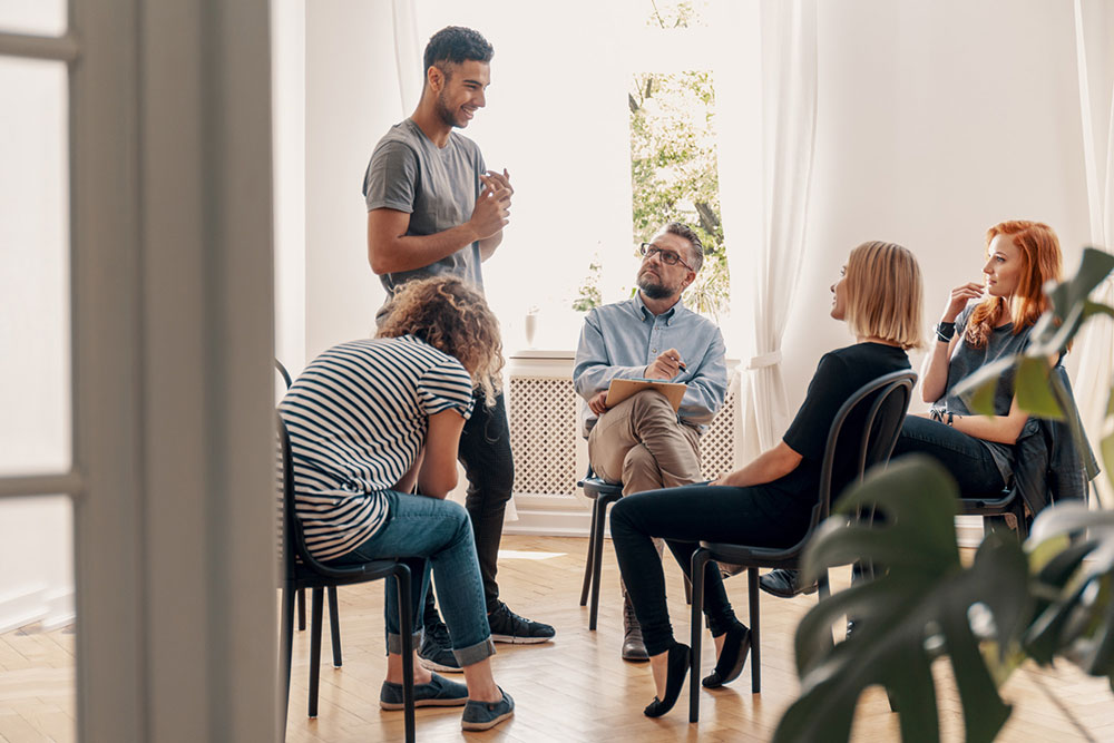 man sharing during group therapy