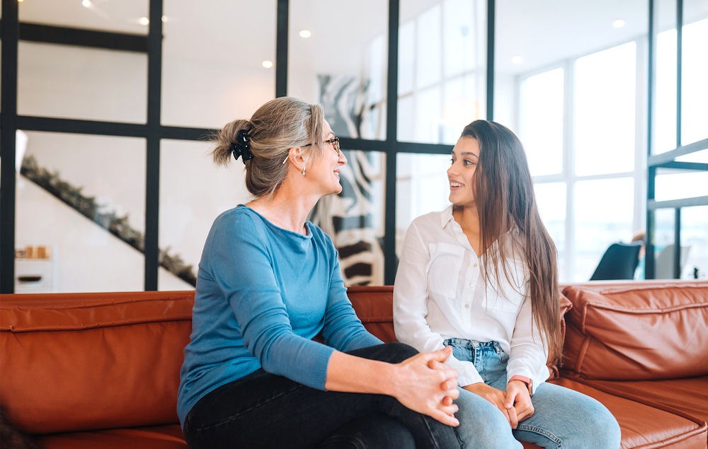 women sitting on couch talking