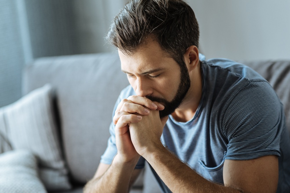 concerned man with hands pressed against face