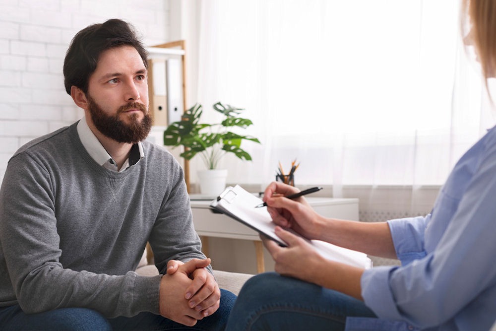 a man with addiction issue is talking to his therapist